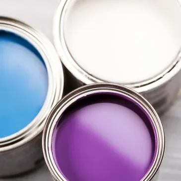 Three cans of paint are shown in a row.