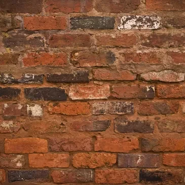 A brick wall with some type of graffiti on it