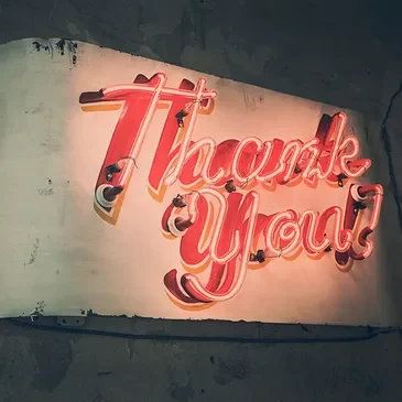 A neon sign that says " thank you ".