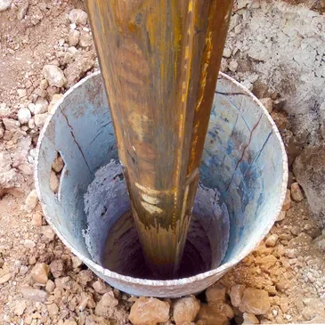 A bucket of water is pouring into the ground.