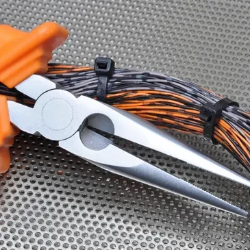 A pair of scissors with orange handles and wires.